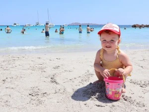 Kleinkind spielt am Strand in Sardinien