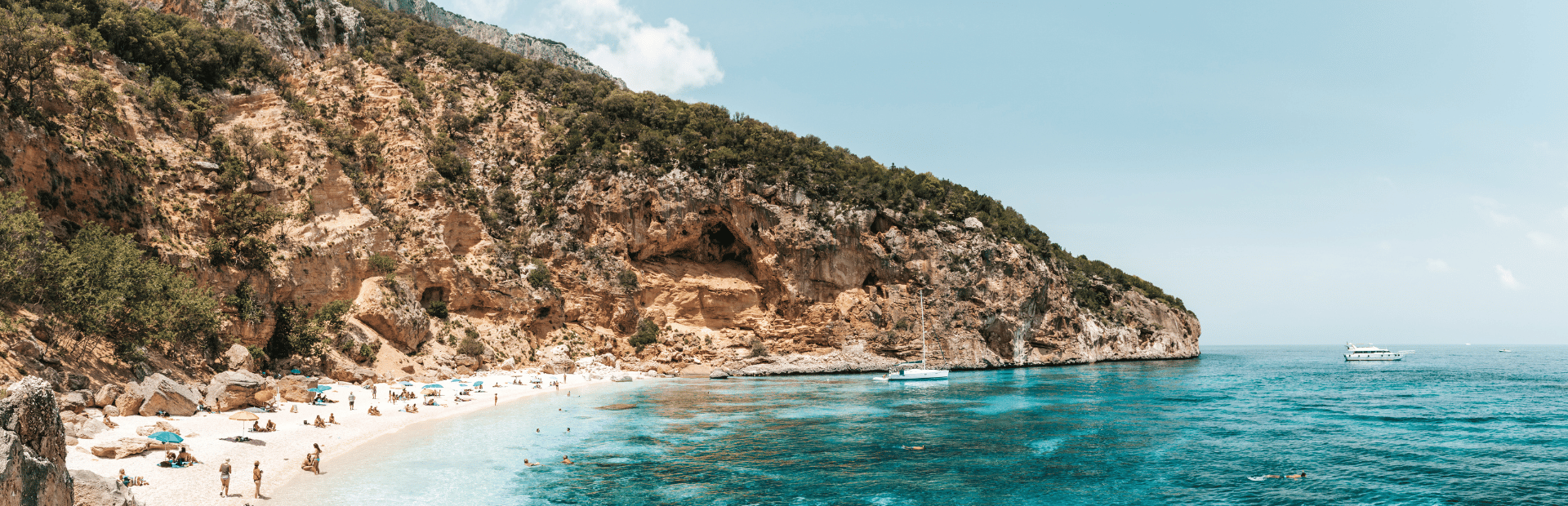 Segelboot in einer Bucht mit Strand in Sardinien, Italien