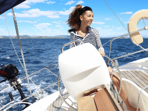 Frau lenkt das Segelschiff bei Sardinien