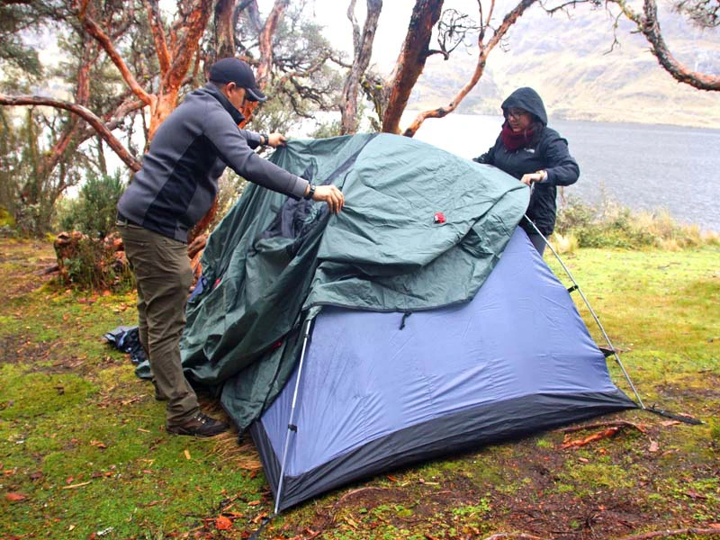 Zwei Personen bauen ein Zelt auf