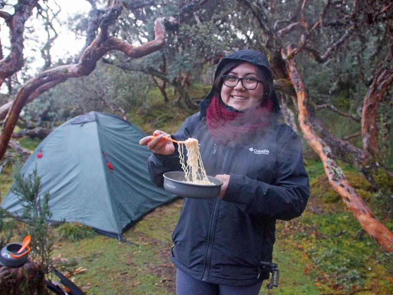 Frau isst Nudeln im Cajas Nationalpark in Ecuador