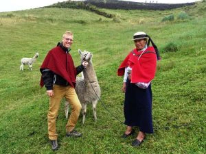Tourist mit Lama und Einheimischer in Ecuador