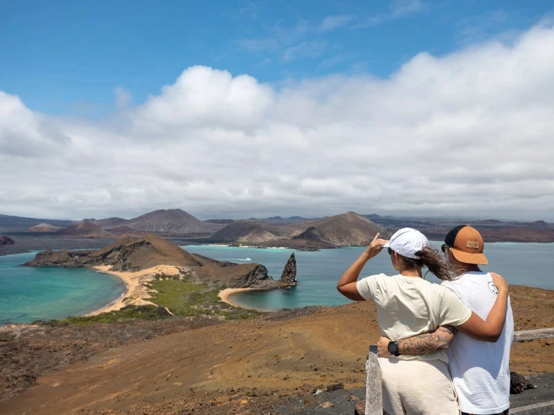 Paar schaut auf den Pinnacle Rock auf den Galapagos Inseln in Ecuador