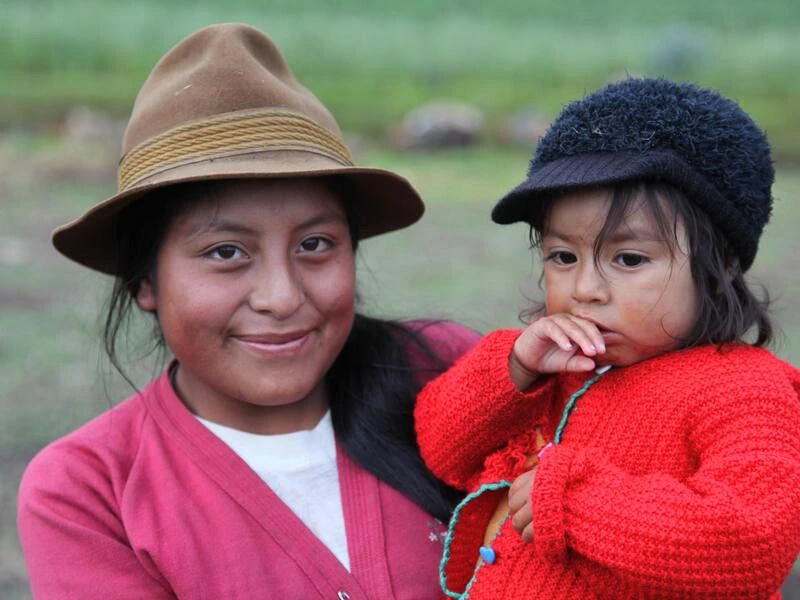Frau mit Kind auf dem Arm in Guamote in Ecuador