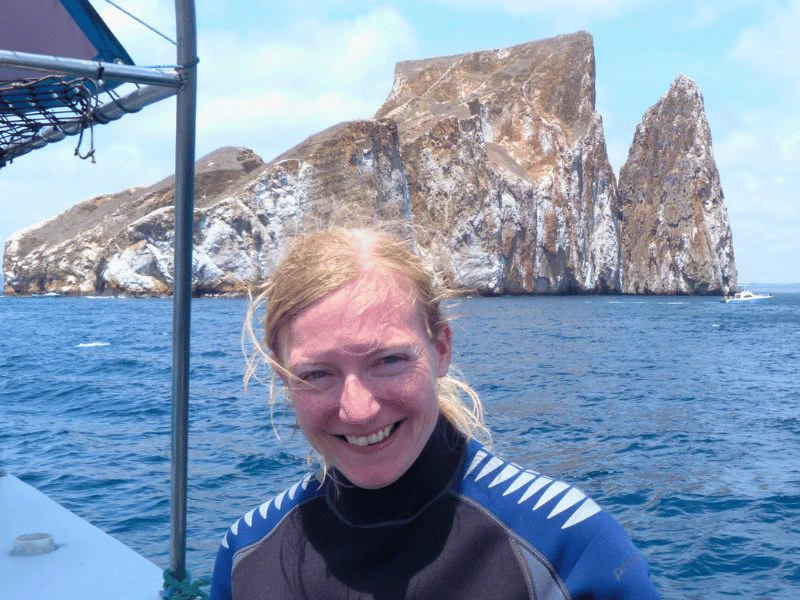 Frau im Neoprenanzug vor Kicker Rock