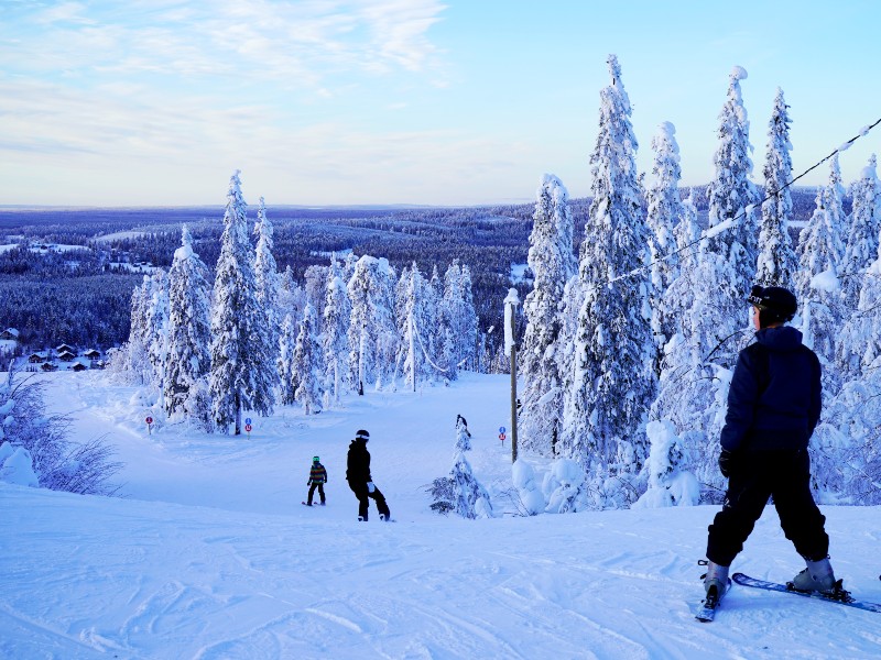 Reisende beim Skifahren in Ylläs in Finnland