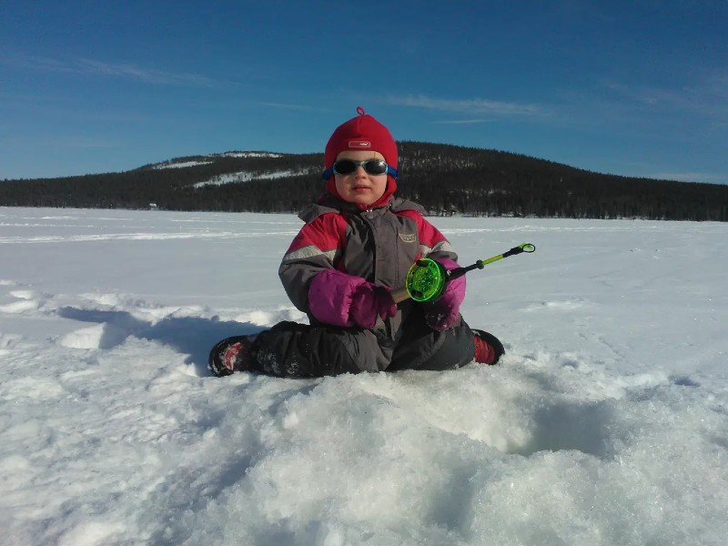 Kind beim Eisfischen in Finnland