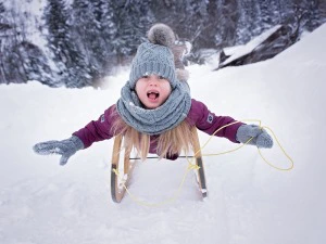Mädchen auf einem Schlitten in Finnland