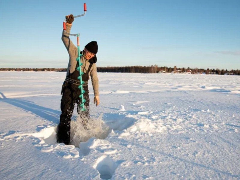 Mann beim Eisfischen in Schweden