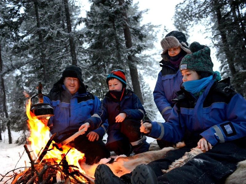 Familie am Lagerfeuer in Lappland