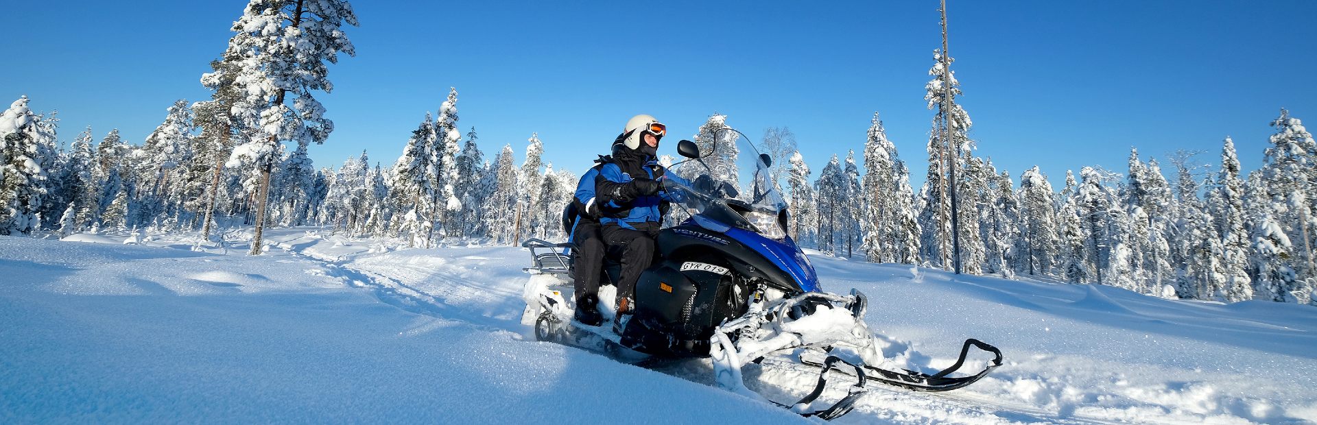 Reisende auf einem Schneemobil in Lappland