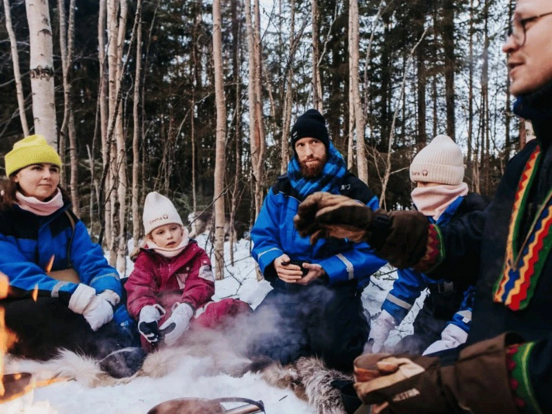 Familie mit Sami am Lagerfeuer in Lappland