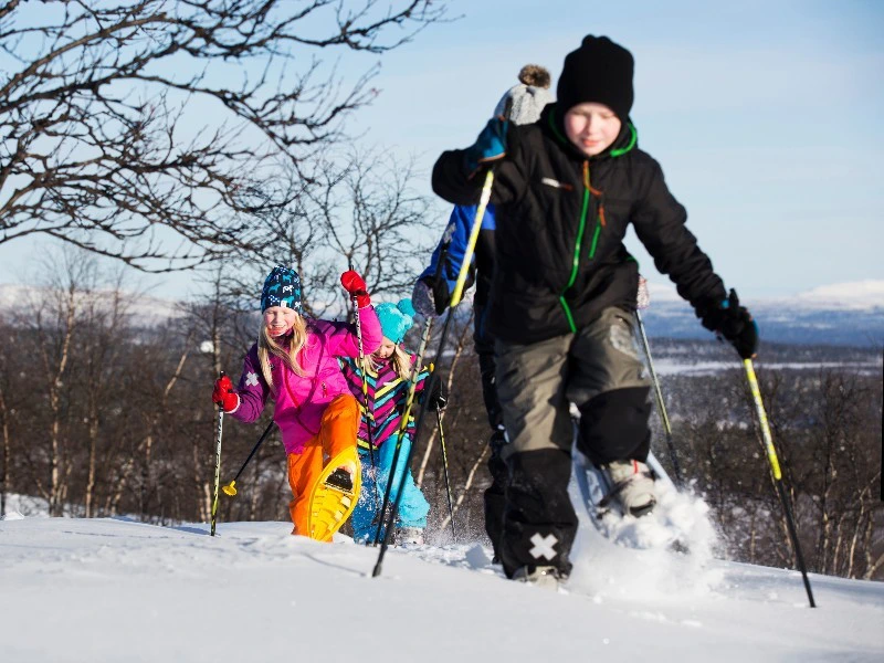 Kinder toben im Schnee in Lappland