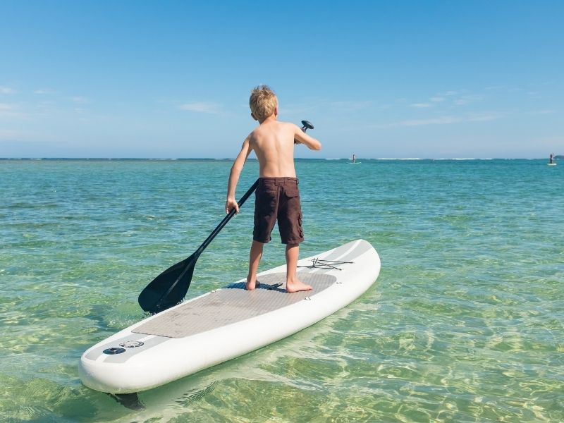 Kind auf Stand-Up Paddleboard an der Costa de la Luz, Spanien