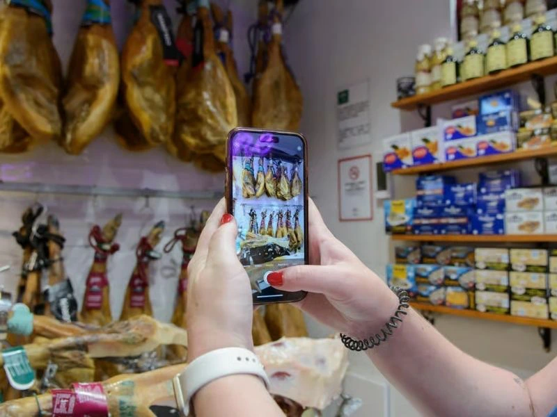 Teilnehmer fotografiert Schinken auf der Tapastour in Granada, Spanien