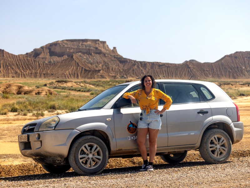 Frau vor Allradwagen bei Tour durch die Halbwüste Bardenas Reales, Spanien