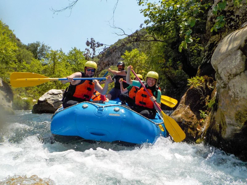 Raftingboot mit Menschen auf einem Fluss bei einer Raftingtour