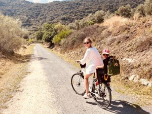 Frau mit Kind auf dem Fahrrad auf der Via Verde, Spanien