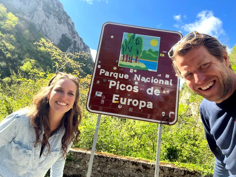 Wanderer vorm Schild des Nationalparks Picos de Europa, Spanien
