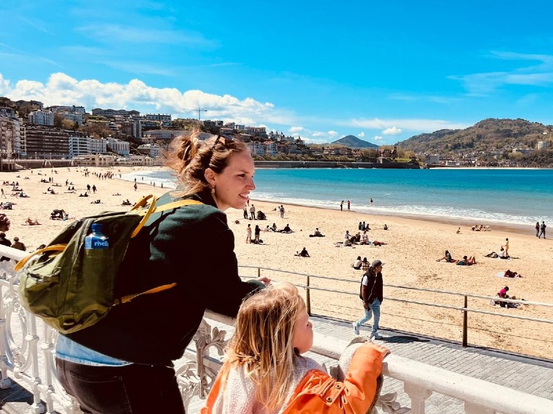 Frau mit Kind mit Blick auf den Strand in San Sebastian