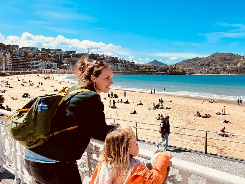Frau mit Kind mit Blick auf den Strand in San Sebastian
