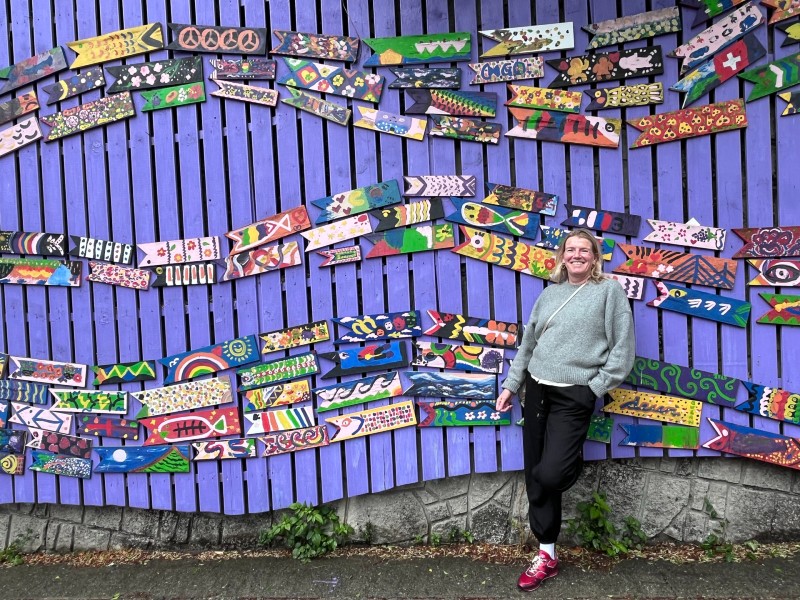 Toursitin vor einer bunt verzierten Wand in Busan, Südkorea
