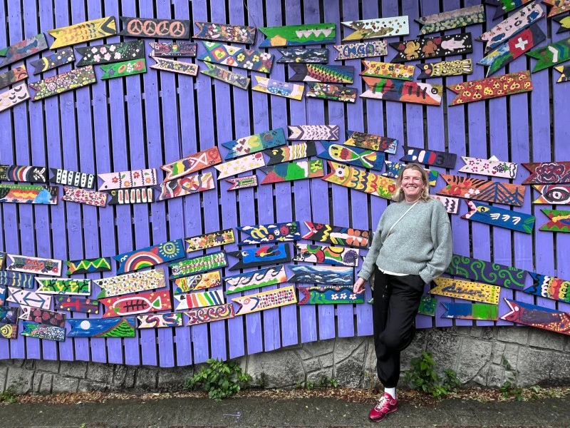 Toursitin vor einer bunt verzierten Wand in Busan, Südkorea