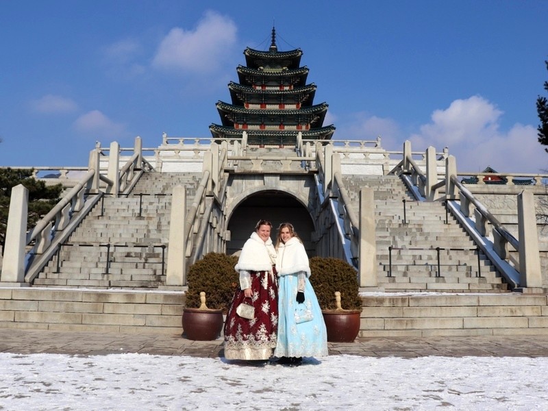 Zwei Touristinnen vor dem Gyeongbokgung Palace in Seoul in traditioneller Kleidung