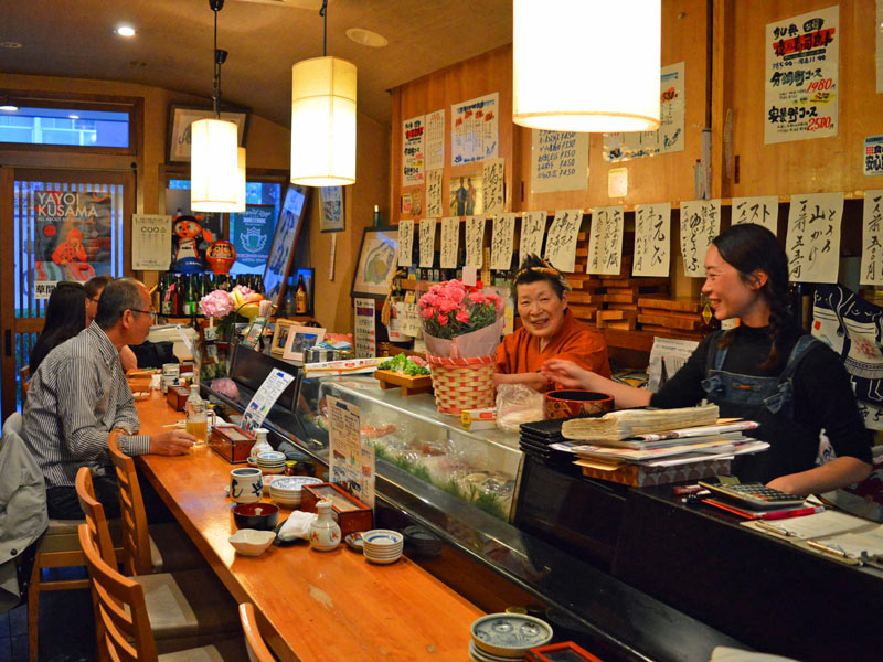 Volle Sushibar mit offener Theke in Tokio