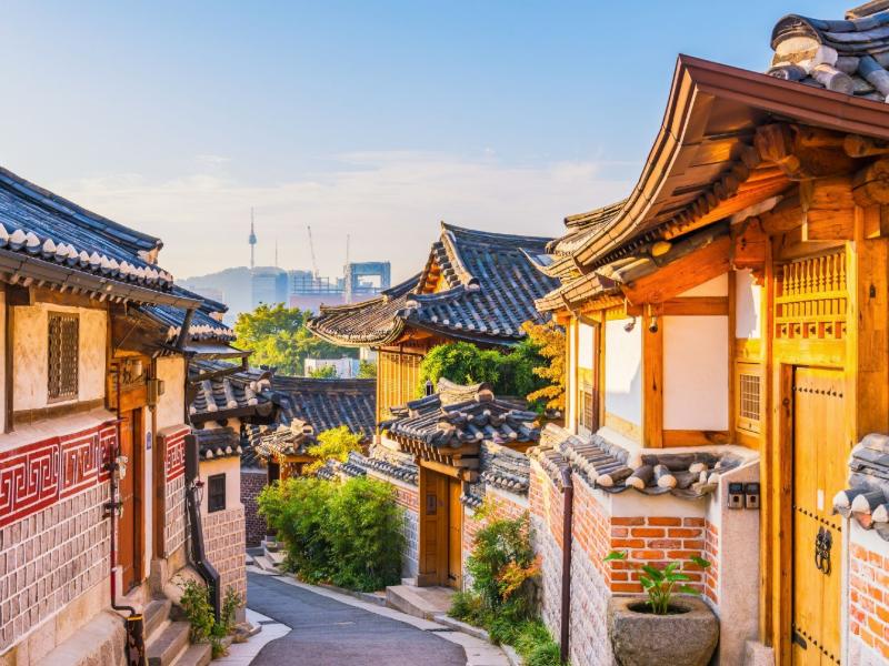 Bukchon Hanok Dorf in Seoul mit traditionellen Häusern und Wolkenkratzern im Hintergrund