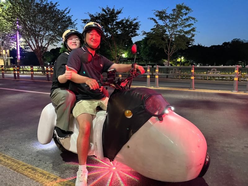 Zwei einheimische auf einem futuristischen Roller in Gyeongju, Südkorea