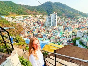 Touristin schaut von einem Aussichtspunkt auf die bunten Häuser in Busan, Südkorea