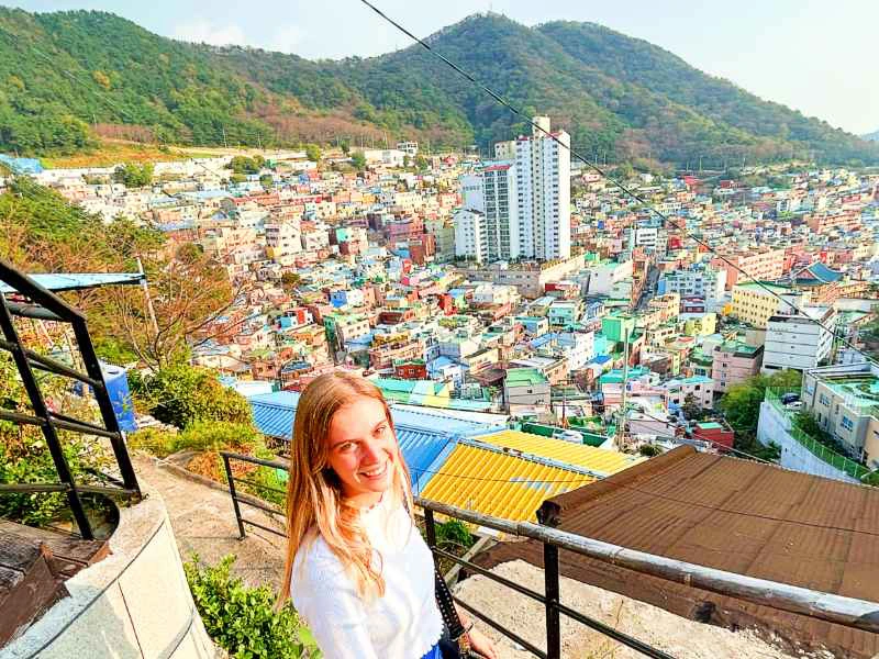Touristin schaut von einem Aussichtspunkt auf die bunten Häuser in Busan, Südkorea