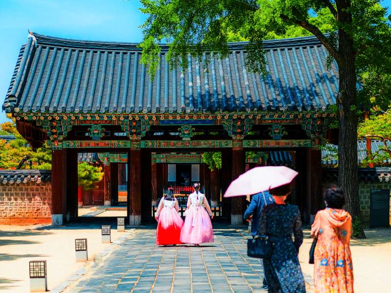 Koreaner in traditioneller Hanbok Kleidung vor einem Tempel in Südkorea