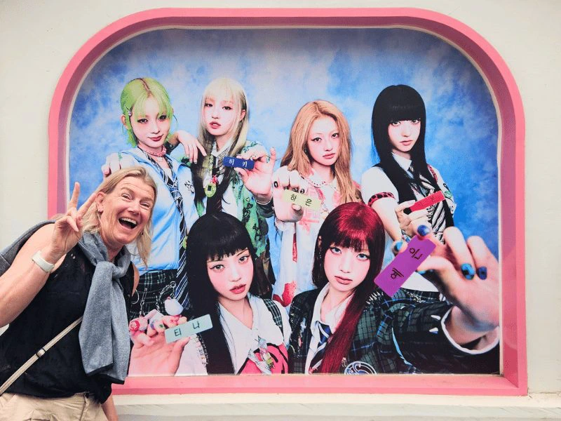 Touristin vor Poster einer K-Pop Gruppe in Südkorea