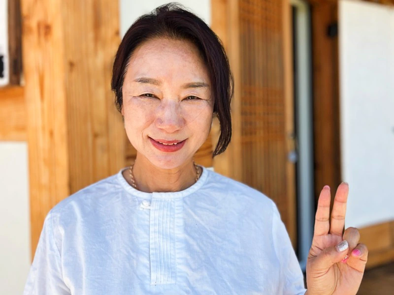 Südkoreanerin lächelt und zeigt Peace Zeichen